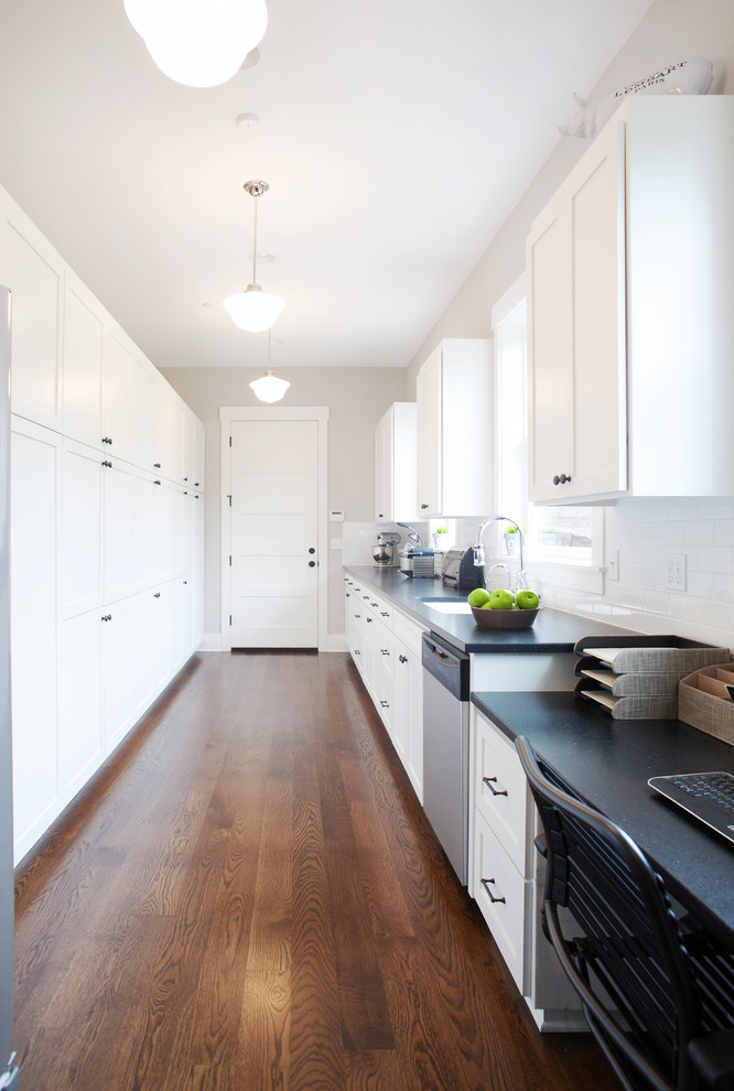 Inspiration for a transitional single-wall enclosed kitchen remodel in Portland with an undermount sink, shaker cabinets, white cabinets, granite countertops, white backsplash, subway tile backsplash and stainless steel appliances