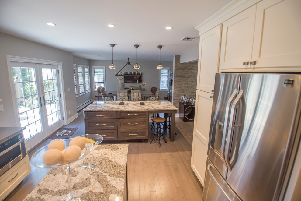 Eat-in kitchen - mid-sized transitional l-shaped dark wood floor eat-in kitchen idea in New York with an undermount sink, recessed-panel cabinets, beige cabinets, quartz countertops, multicolored backsplash, subway tile backsplash, stainless steel appliances and two islands