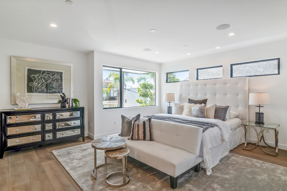 Transitional master bedroom in Los Angeles with white walls, medium hardwood floors, no fireplace and brown floor.