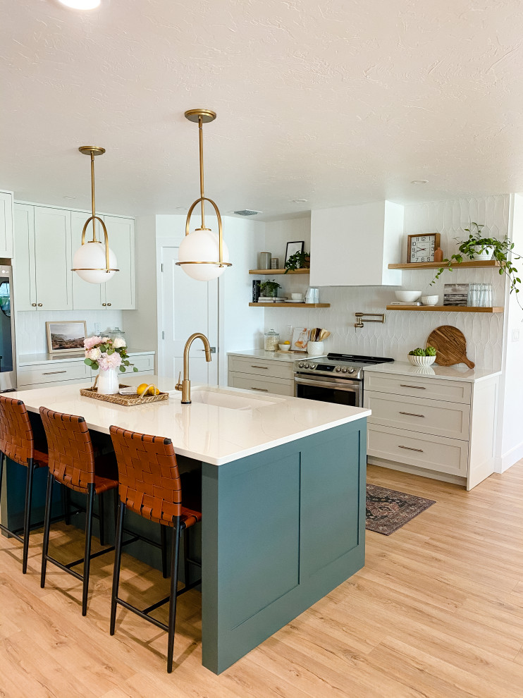 Photo of a mid-sized modern l-shaped eat-in kitchen in Tampa with shaker cabinets, beige cabinets, quartzite benchtops, white splashback, ceramic splashback, stainless steel appliances, vinyl floors, with island and white benchtop.
