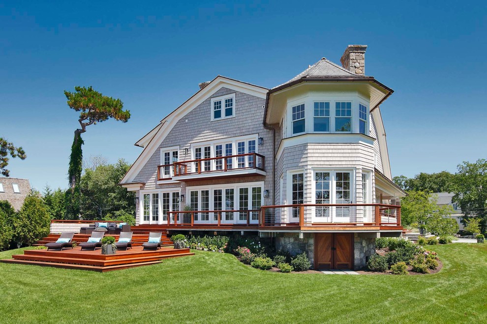 Beach style three-storey grey house exterior in New York with wood siding, a gambrel roof and a shingle roof.