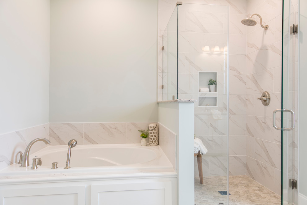 This is an example of a mid-sized transitional master bathroom in New Orleans with shaker cabinets, white cabinets, a drop-in tub, a corner shower, a two-piece toilet, white tile, ceramic tile, green walls, ceramic floors, an undermount sink, granite benchtops, white floor, a hinged shower door and white benchtops.