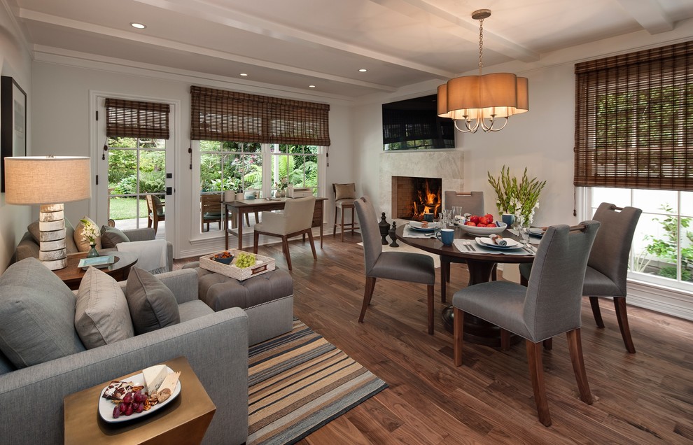 This is an example of a mid-sized transitional open plan dining in Los Angeles with beige walls, medium hardwood floors, a standard fireplace, a stone fireplace surround and brown floor.