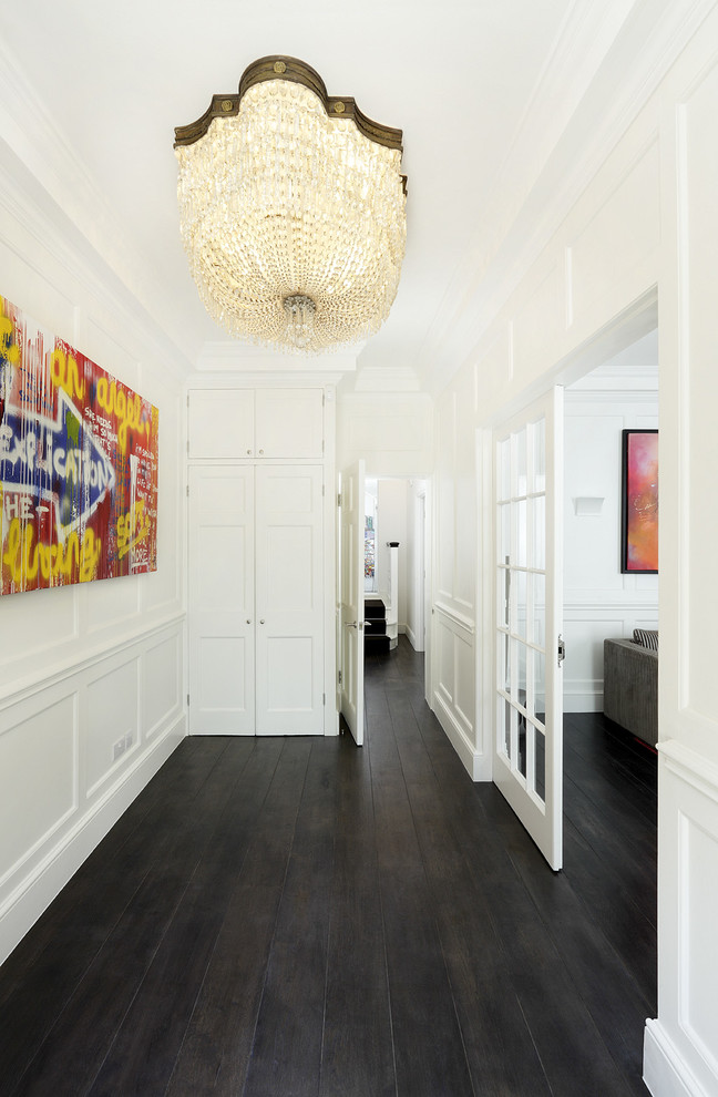 Inspiration for a mid-sized transitional entry hall in London with white walls and black floor.