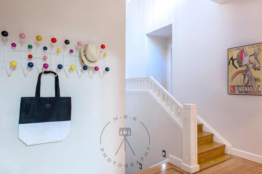 Mid-sized light wood floor and yellow floor entry hall photo with white walls