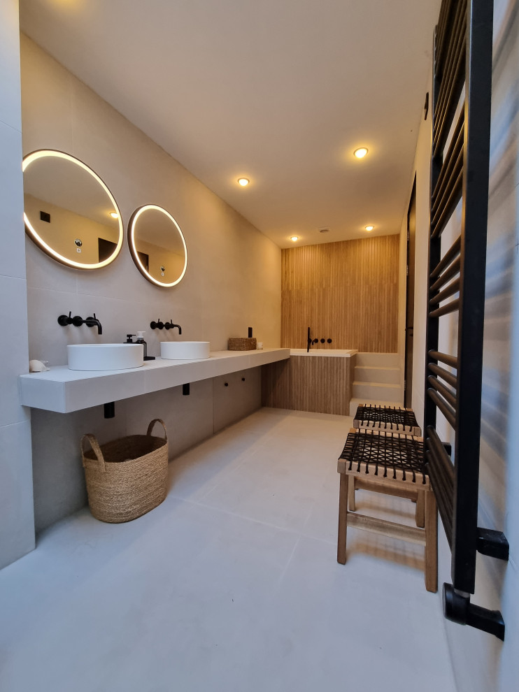 Photo of a large scandinavian ensuite bathroom in Other with white cabinets, a japanese bath, a walk-in shower, a wall mounted toilet, white tiles, wood-effect tiles, white walls, porcelain flooring, a vessel sink, tiled worktops, white floors, white worktops, a shower bench, double sinks and a floating vanity unit.