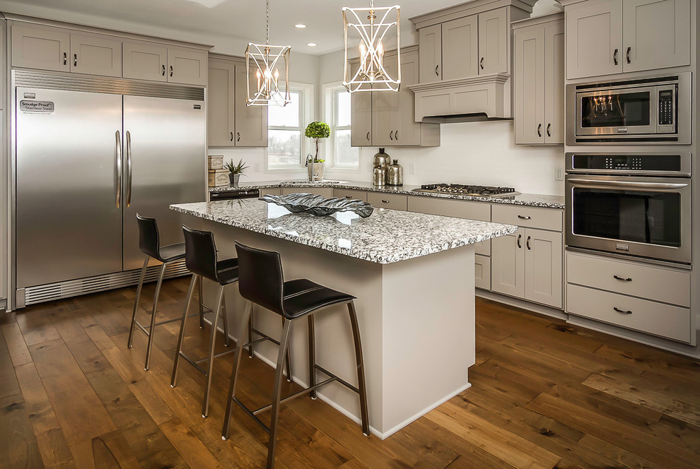 Mid-sized transitional l-shaped separate kitchen in Minneapolis with an undermount sink, shaker cabinets, beige cabinets, granite benchtops, stainless steel appliances, medium hardwood floors and with island.