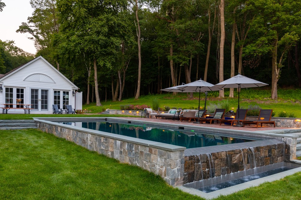 Photo of a traditional backyard rectangular lap pool in New York with a water feature.