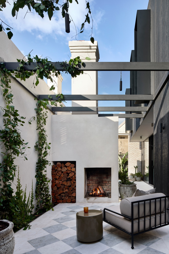 Photo of a transitional patio in Melbourne with with fireplace, tile and no cover.