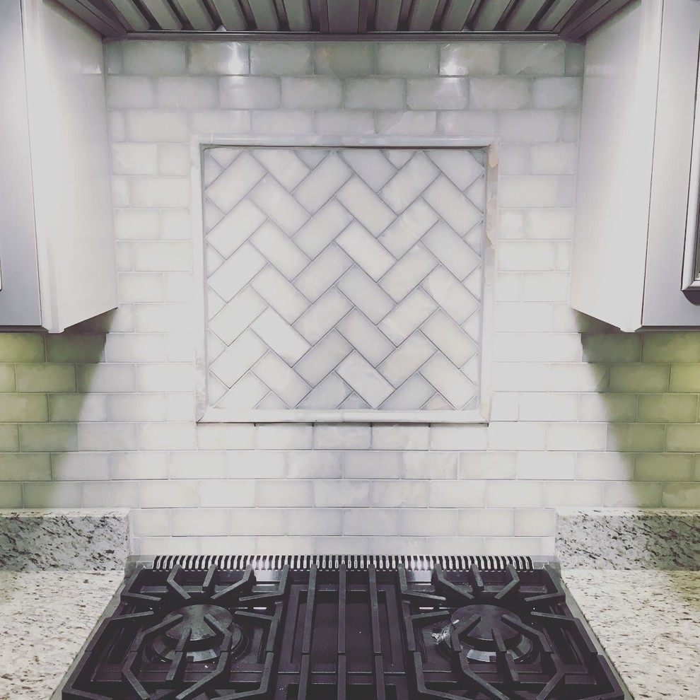 Inspiration for a large transitional l-shaped kitchen remodel in Boston with an undermount sink, raised-panel cabinets, gray cabinets, granite countertops, gray backsplash, subway tile backsplash, stainless steel appliances and multicolored countertops