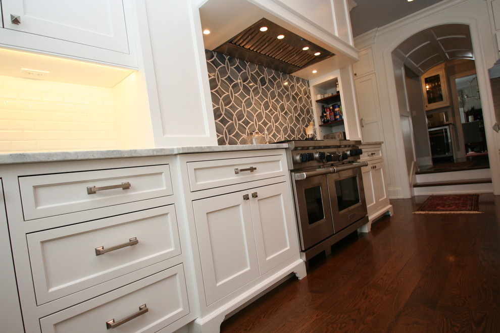 Inspiration for a large transitional l-shaped dark wood floor open concept kitchen remodel in Chicago with flat-panel cabinets, white cabinets, granite countertops, blue backsplash, ceramic backsplash, stainless steel appliances and an island
