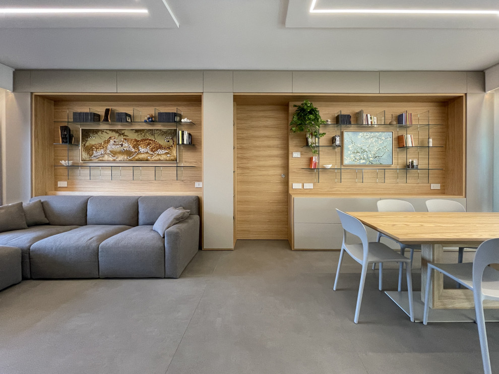 Idee per un soggiorno minimalista di medie dimensioni e aperto con libreria, pavimento in gres porcellanato, parete attrezzata, pavimento grigio, boiserie, pareti bianche e soffitto ribassato