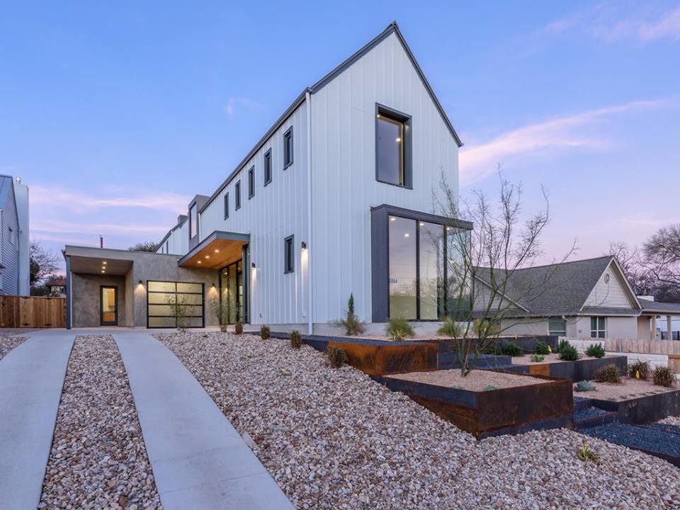 This is an example of a large contemporary two-storey white exterior in Austin with metal siding.