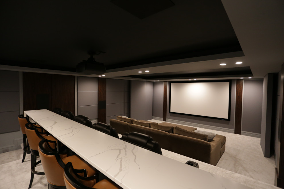 Idées déco pour une grande salle de cinéma contemporaine fermée avec un mur gris, moquette, un écran de projection et un sol beige.