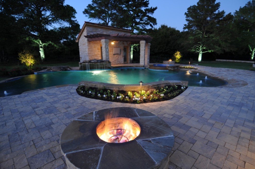 Photo of a mid-sized contemporary backyard rectangular lap pool in Dallas with a water feature and brick pavers.