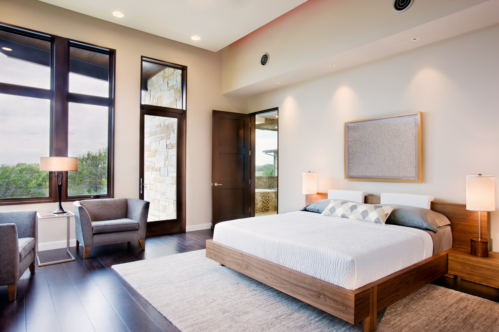 Large contemporary master bedroom in Austin with white walls, dark hardwood floors, no fireplace and brown floor.