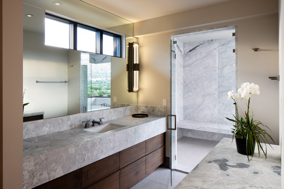 This is an example of an expansive contemporary master wet room bathroom in Salt Lake City with flat-panel cabinets, brown cabinets, a japanese tub, beige walls, porcelain floors, an undermount sink, quartzite benchtops, grey floor, a hinged shower door, grey benchtops, a double vanity and a built-in vanity.