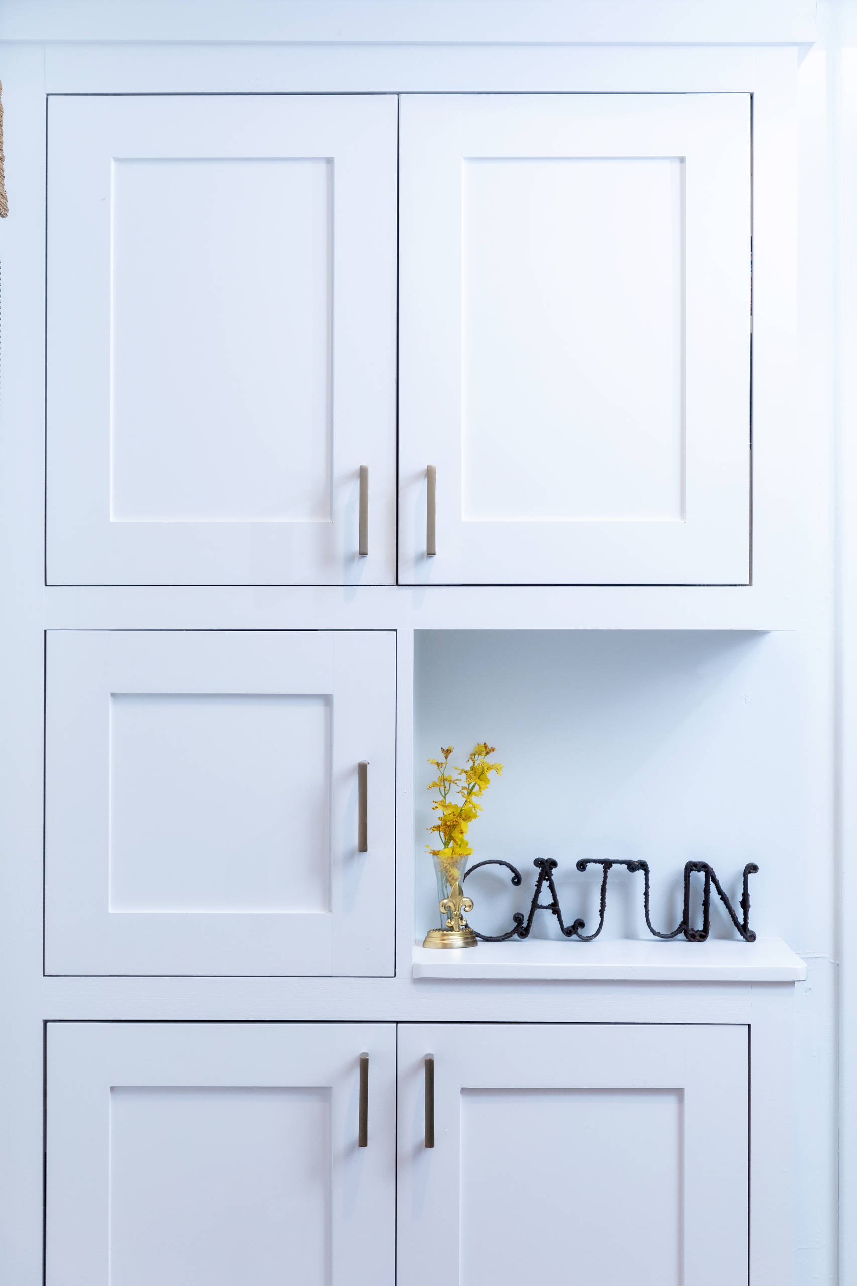 White, recessed-panel upper, middle and lower cabinet with gold hardware.  Space Planning by Ourso Designs. Photo by Collin Richie (Collin Richie Photography).