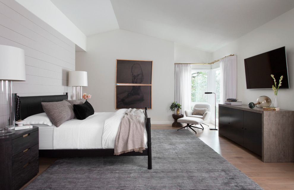 Inspiration for a contemporary bedroom in Austin with white walls, medium hardwood floors and brown floor.