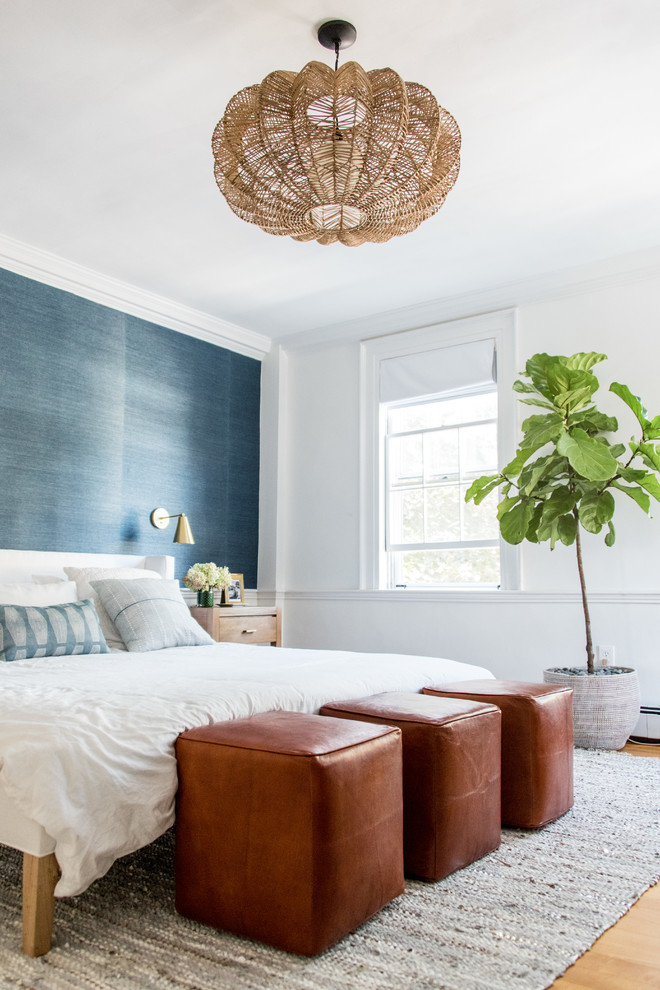 Photo of a beach style master bedroom in Boston with white walls, medium hardwood floors and brown floor.