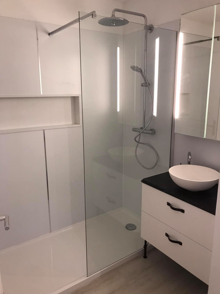Aménagement d'une petite salle d'eau contemporaine avec une douche ouverte, une plaque de galets, un mur blanc, un sol en vinyl, un plan vasque, un sol blanc, une niche et meuble simple vasque.