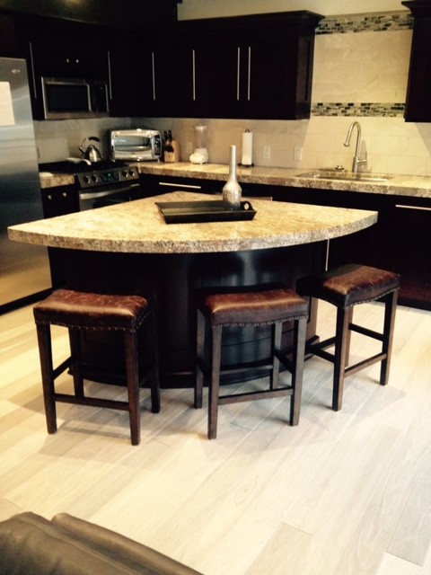 Open concept kitchen - small transitional l-shaped light wood floor open concept kitchen idea with a drop-in sink, dark wood cabinets, granite countertops, beige backsplash, porcelain backsplash, stainless steel appliances and an island