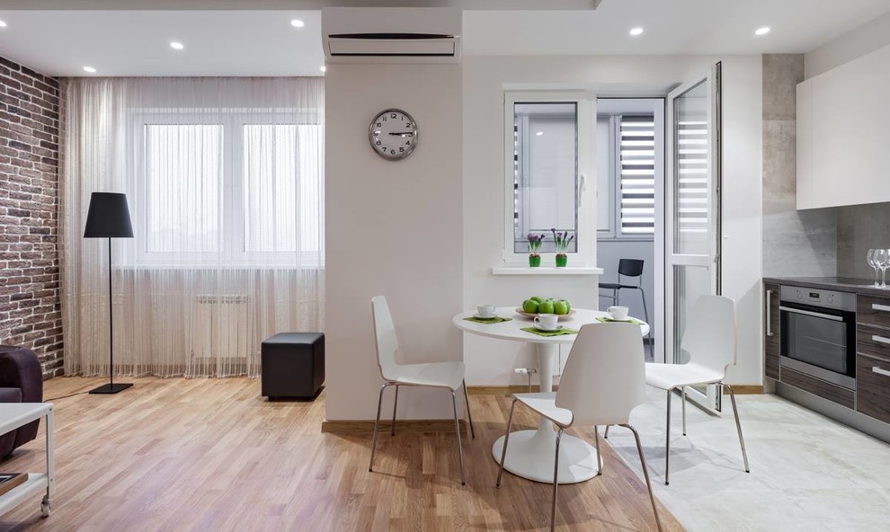 Mid-sized transitional medium tone wood floor and brown floor great room photo with white walls and no fireplace