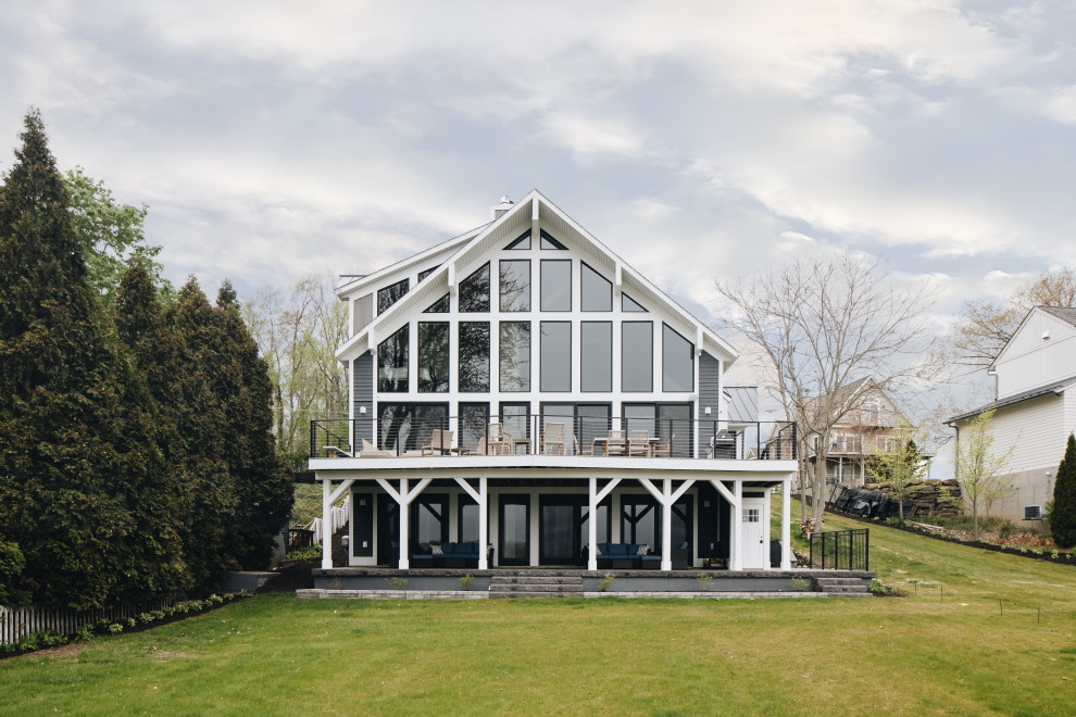 Inspiration pour une grande façade de maison bleue chalet en planches et couvre-joints à trois étages et plus avec un revêtement mixte, un toit à deux pans, un toit mixte et un toit gris.