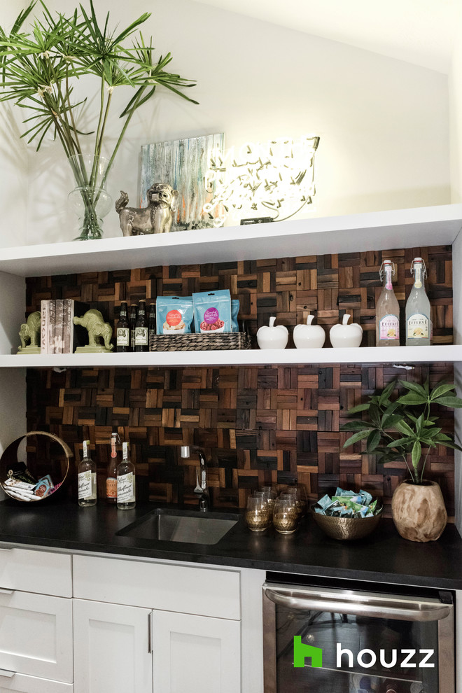 Design ideas for a small contemporary single-wall wet bar with an undermount sink, shaker cabinets, white cabinets, brown splashback, timber splashback and black benchtop.