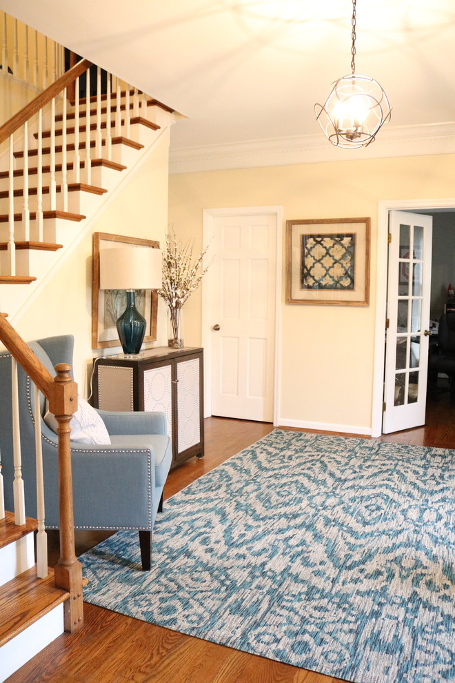 Example of a small transitional medium tone wood floor foyer design in Cincinnati with yellow walls