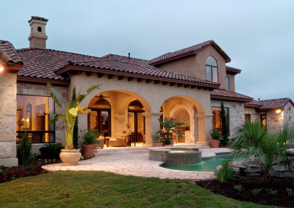This is an example of a mediterranean backyard patio in Houston with an outdoor kitchen.