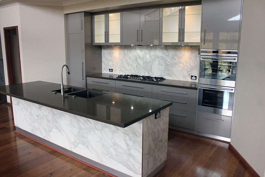 Photo of a contemporary kitchen in Perth with an undermount sink, grey cabinets, white splashback, stone slab splashback, medium hardwood floors and with island.