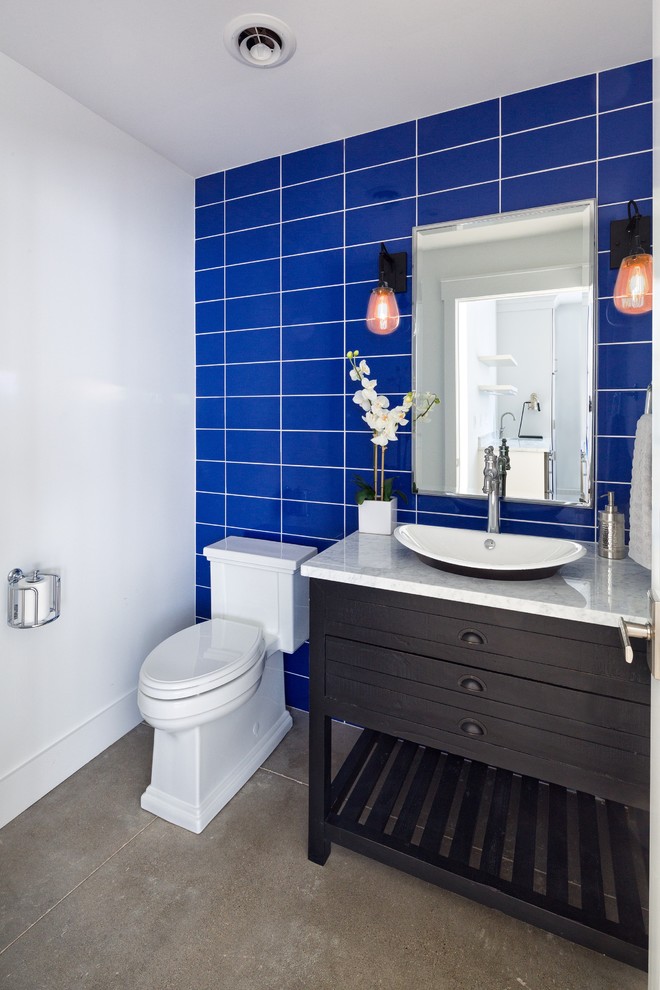 Inspiration for a small transitional bathroom in Denver with furniture-like cabinets, dark wood cabinets, a two-piece toilet, blue tile, ceramic tile, white walls, concrete floors, a vessel sink, marble benchtops and grey floor.