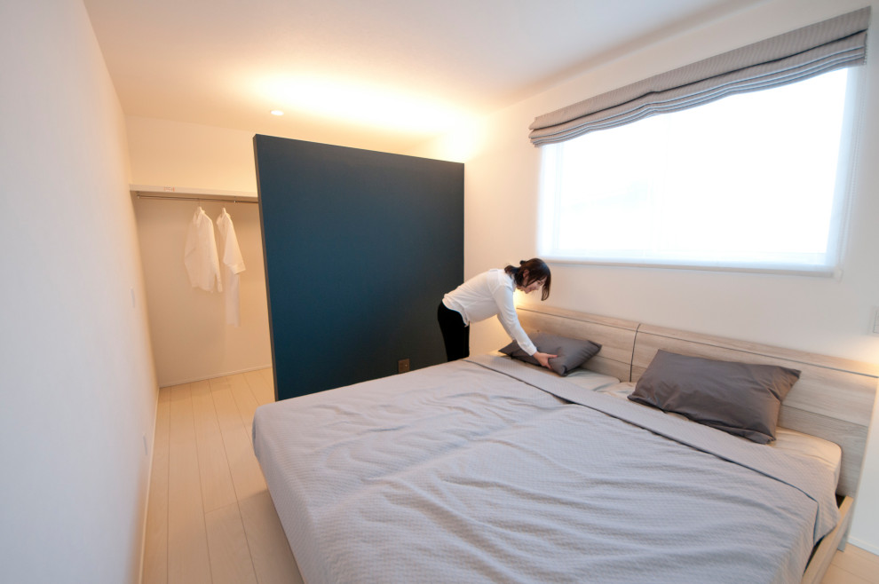 На фото: хозяйская спальня среднего размера в стиле модернизм с белыми стенами, полом из фанеры, белым полом, потолком с обоями и обоями на стенах с