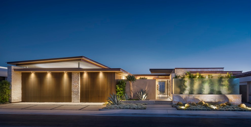 This is an example of a contemporary two-storey exterior in Orange County with stone veneer and a flat roof.