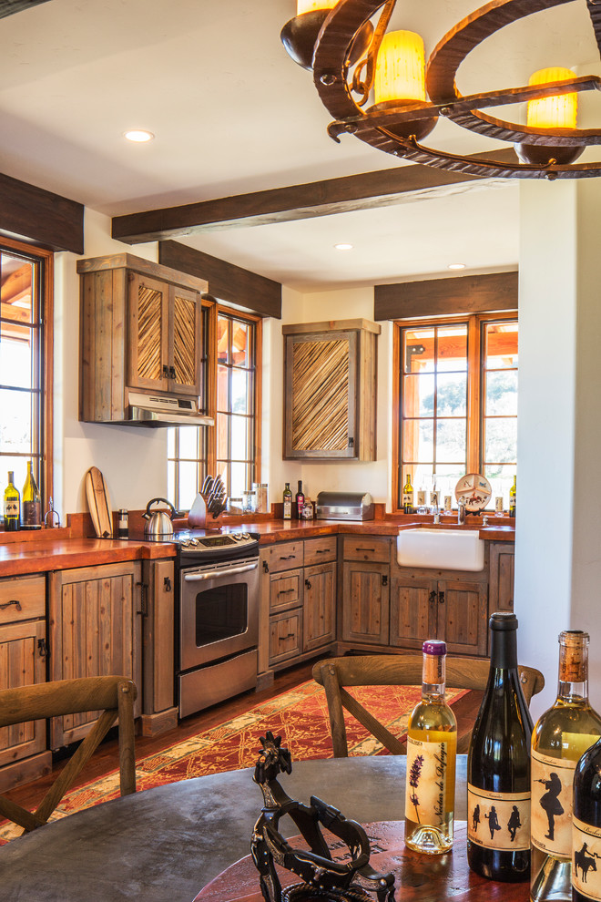 Small mountain style l-shaped dark wood floor eat-in kitchen photo in Santa Barbara with stainless steel appliances, no island, a farmhouse sink, raised-panel cabinets, distressed cabinets and concrete countertops