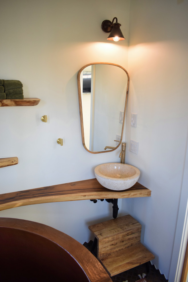 Exempel på ett litet brun brunt en-suite badrum, med öppna hyllor, bruna skåp, ett fristående badkar, en dusch/badkar-kombination, vit kakel, cementkakel, vita väggar, ett fristående handfat, träbänkskiva, brunt golv och dusch med duschdraperi