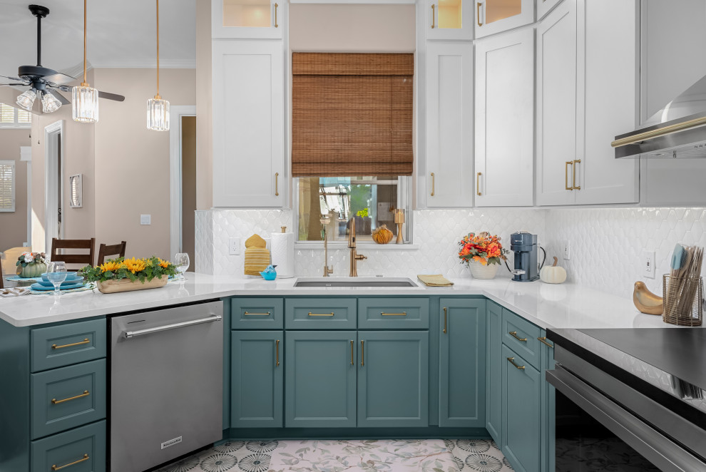 Example of a transitional ceramic tile kitchen design in Austin with an undermount sink, shaker cabinets, white backsplash, porcelain backsplash, stainless steel appliances and white countertops