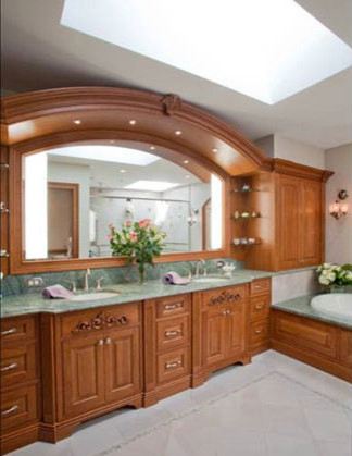 Photo of a mid-sized traditional master bathroom in Philadelphia with raised-panel cabinets, medium wood cabinets, a hot tub, pink tile, stone tile, porcelain floors and marble benchtops.