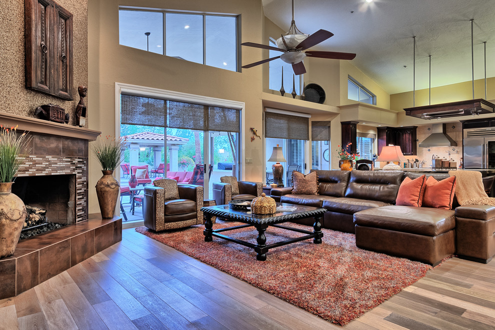 Expansive transitional open concept family room in Phoenix with beige walls, light hardwood floors, a corner fireplace and a tile fireplace surround.