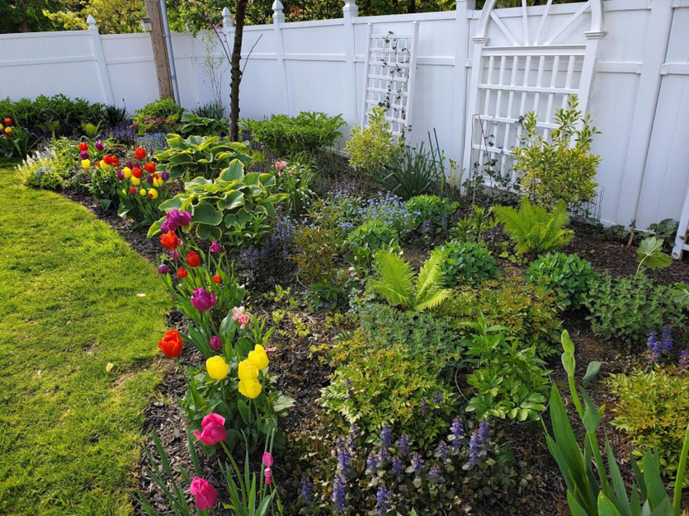 Exemple d'un petit jardin à la française arrière chic au printemps avec un massif de fleurs, une exposition partiellement ombragée et une terrasse en bois.