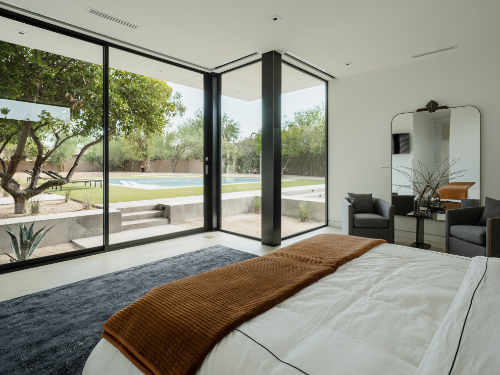 Diseño de dormitorio principal minimalista con paredes blancas y suelo de madera clara