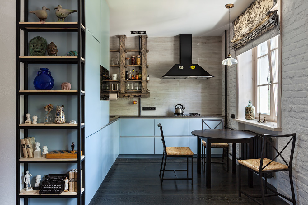 This is an example of a mid-sized contemporary l-shaped open plan kitchen in Other with an undermount sink, flat-panel cabinets, grey cabinets, beige splashback, porcelain splashback, black appliances, dark hardwood floors, no island, black floor and black benchtop.