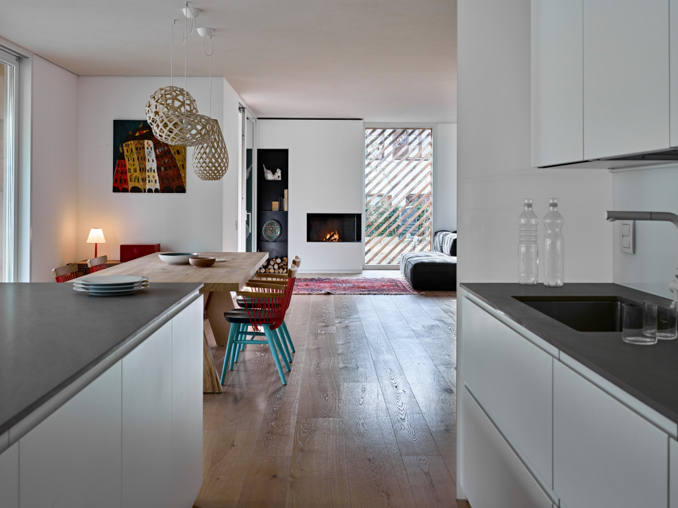 Ispirazione per una cucina nordica con ante a filo, ante bianche, top in superficie solida, pavimento in legno massello medio, pavimento beige e top grigio