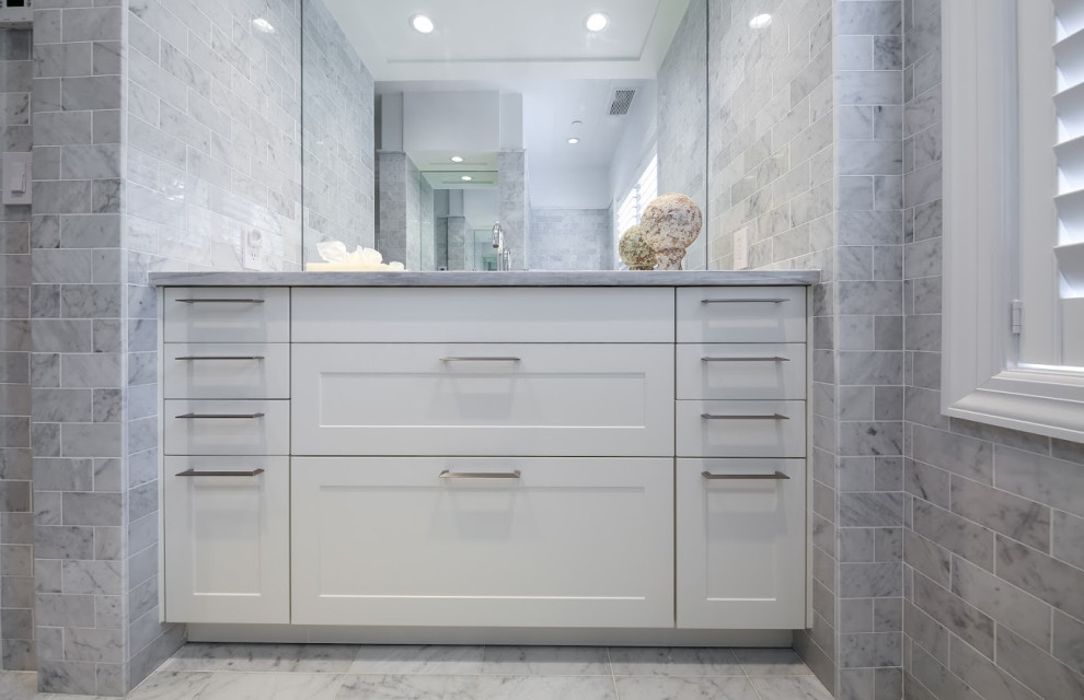 This is an example of an expansive modern bathroom in New York with shaker cabinets and white cabinets.