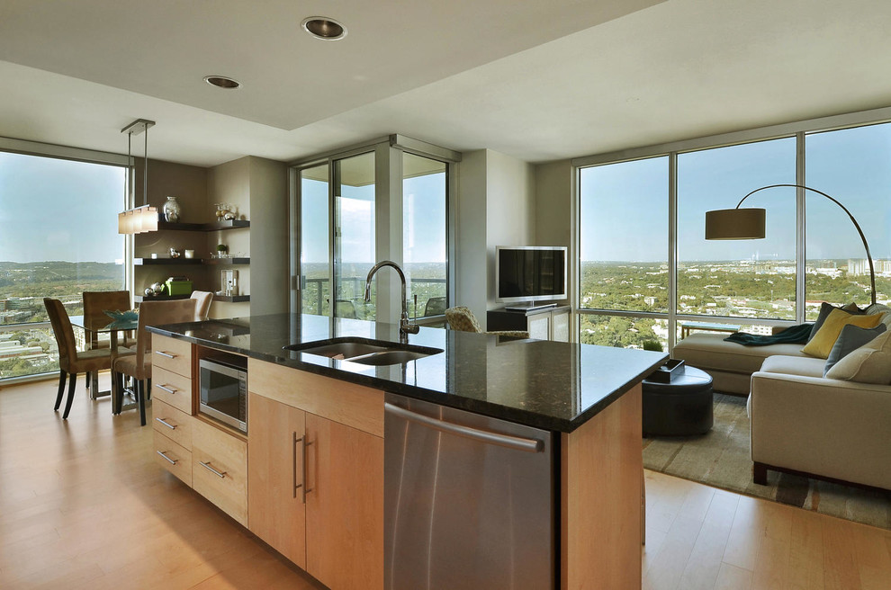 Example of a small transitional galley light wood floor open concept kitchen design in Austin with a double-bowl sink, flat-panel cabinets, light wood cabinets, granite countertops, beige backsplash, mosaic tile backsplash, stainless steel appliances and an island