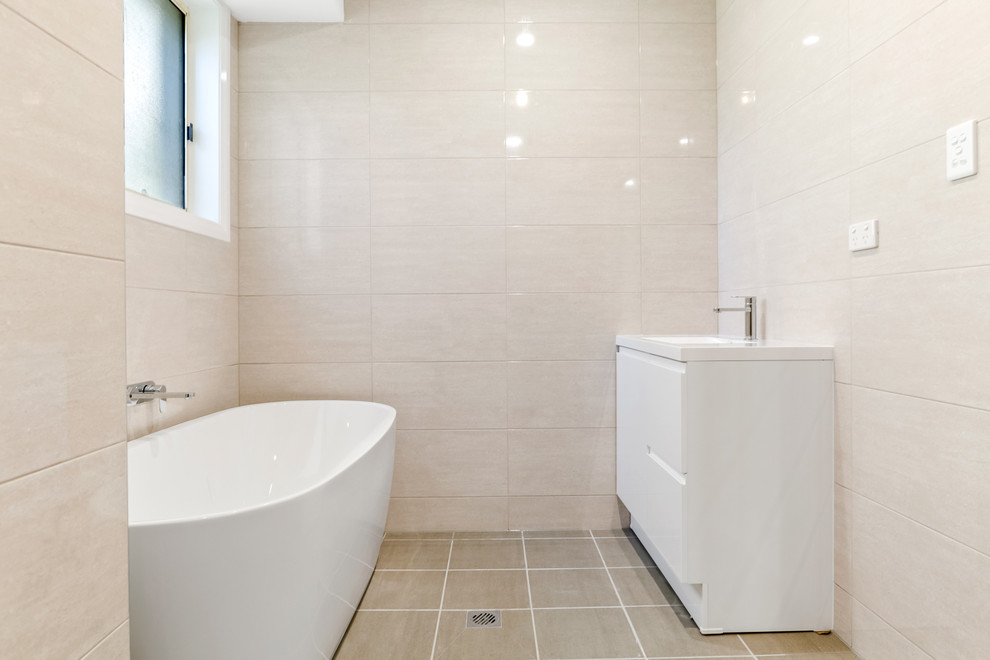 Design ideas for a large modern master bathroom in Sydney with flat-panel cabinets, white cabinets, a freestanding tub, ceramic tile, black walls, ceramic floors, a drop-in sink, marble benchtops, beige floor and beige benchtops.