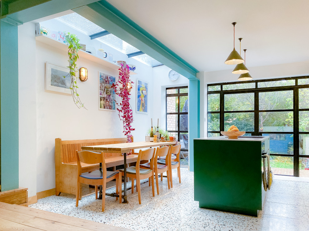 This is an example of a small contemporary galley eat-in kitchen in Oxfordshire with a drop-in sink, flat-panel cabinets, green cabinets, quartz benchtops, white splashback, ceramic splashback, stainless steel appliances, terrazzo floors, with island, multi-coloured floor and white benchtop.