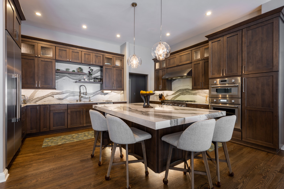 Inspiration for a transitional eat-in kitchen remodel in Milwaukee with an undermount sink, shaker cabinets, white backsplash, stainless steel appliances, an island and white countertops