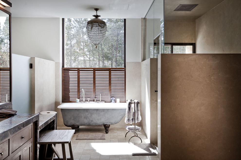 This is an example of a wet room bathroom in Madrid with furniture-like cabinets, black cabinets, a claw-foot tub, beige tile, ceramic tile, marble benchtops, black benchtops and a built-in vanity.